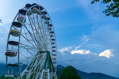 Brightly colored Ferris wheel against the blue skyの写真素材