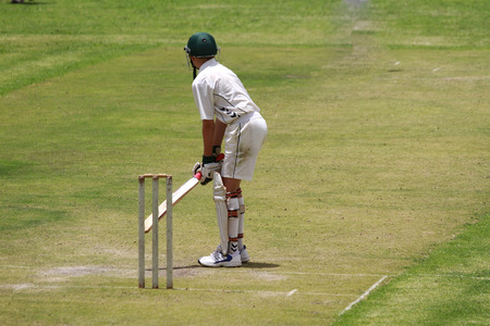  A young school boy cricket player is preparing to attack the ball.の写真素材