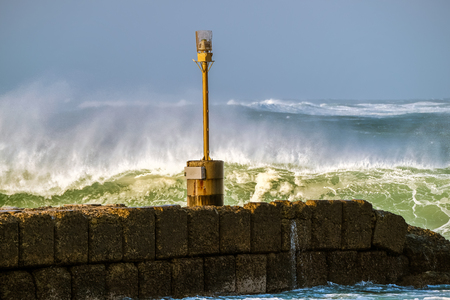 A big wave breaking near the pierの写真素材