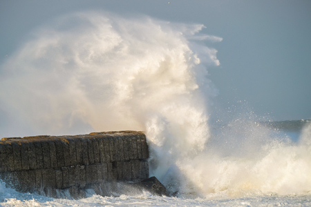 A big wave crashing into the pierの写真素材