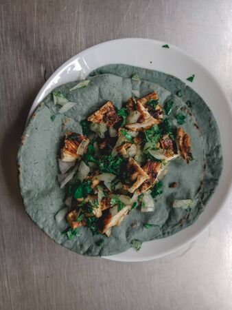 typical mexican dish, homemade chicken taco with coriander and onionの写真素材