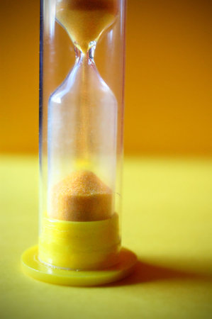 Macro shot of a yellow hour glass out of a childs' board game.
