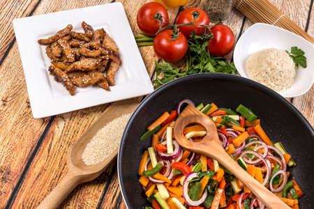Traditional asian food. - chicken stir fry with vegetables,  soya sause and sesame in the wok and rice.の写真素材