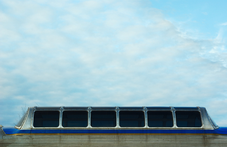 passenger train windows on blue sky with clouds background for textの写真素材
