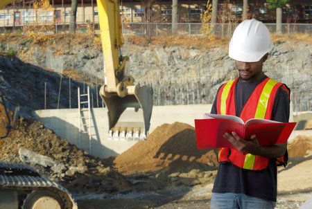 construction worker holding document on excavator site