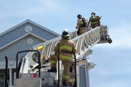three firefighters climbing a ladder fireman at work extinguishing fire