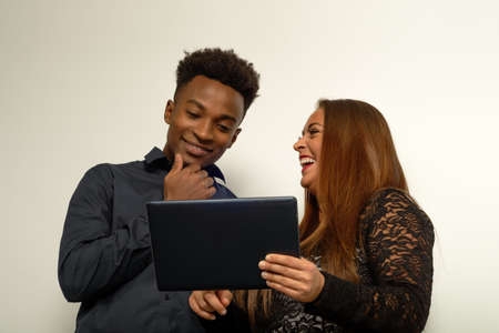 excited girl showing picture on internet holding tablet and laughing with friend social app lifestyleの写真素材