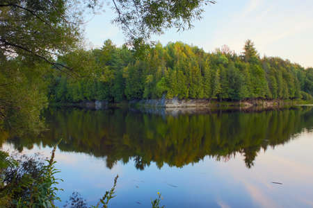 river reflections trees and rock tranquil landscape environment East Angus Quebecの写真素材