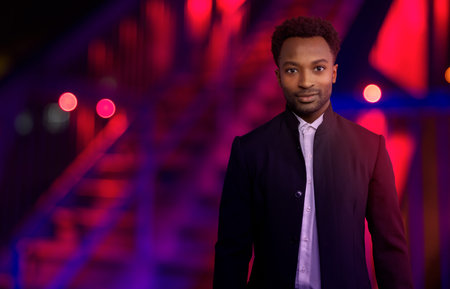 man at night outside wearing black suit urban lifestyle businessman red and blue lights city...