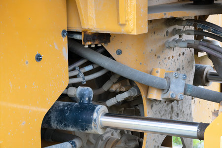 Close-up of a yellow hydraulic engine in heavy construction machinery, showcasing detailed...