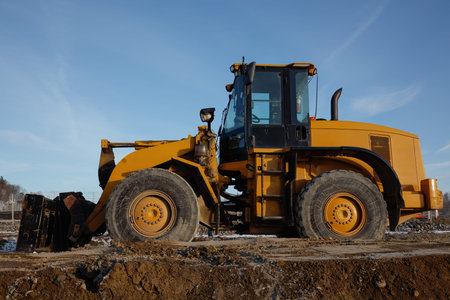 Yellow bulldozer on a construction site, heavy machinery used for earthmoving, excavation, and...