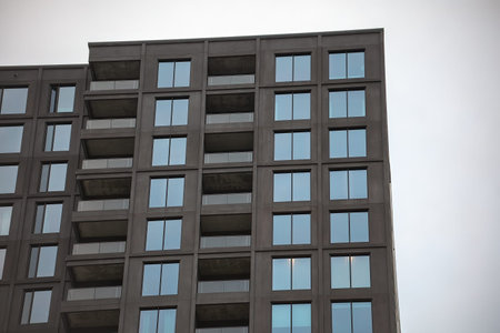 Modern residential apartment building with clean geometric design and multiple balconies....