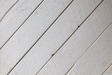 White painted wooden planks arranged diagonally showcase natural grain texture. Perfect rustic-modern background for interior design, coastal themes, and minimalist photography projects.の写真素材