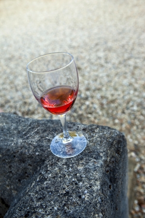 Glass of rose wine on a stone wallの写真素材