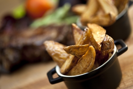 Fried potatoes and piece of steak on a tableの写真素材