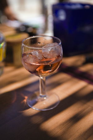 Glass of rose wine on a wooden tableの写真素材