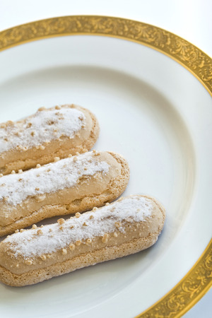 Three sweet biscuits on a golden plateの写真素材