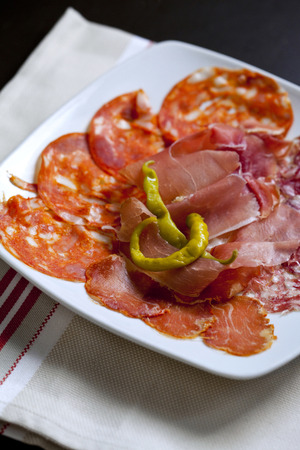 Close up of ham, sausage and peppers in a plateの写真素材