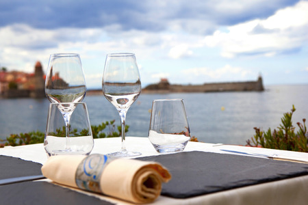 Table set on the terrace of a restaurant facing Mediterranean seaの写真素材