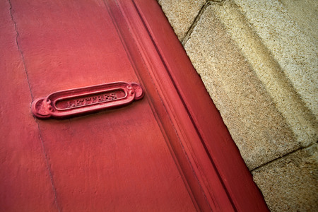 Old French letter box of a red doorの写真素材