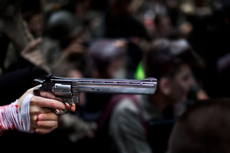 Injured hand and revolver in the crowd