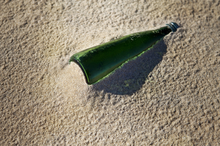 Old glass bottle stranded on the sand of the beach after the tideの写真素材