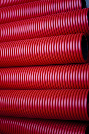 Close up of red plastic pipes on a construction siteの写真素材