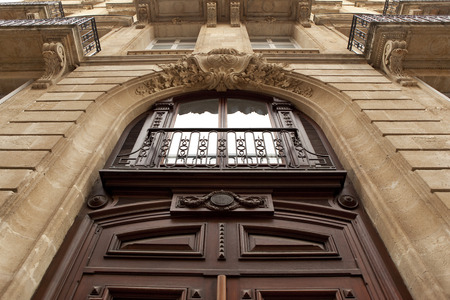 Wooden door and stoned facade of a French mansionの写真素材