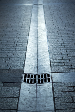 A sink and gutters on a cobbled streetの写真素材