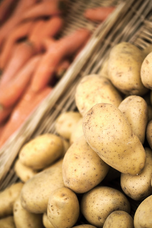 Vegetable in a wicket basket on a market stallの写真素材