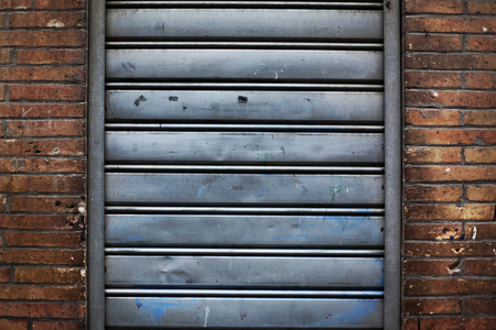 Closed iron curtain and brick wallの写真素材
