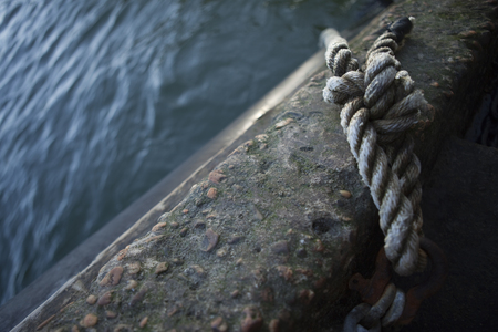 Node of a rope on dock facing the riverの写真素材