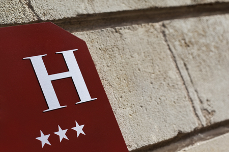 Sign of a three stars hotel on a stone wallの写真素材