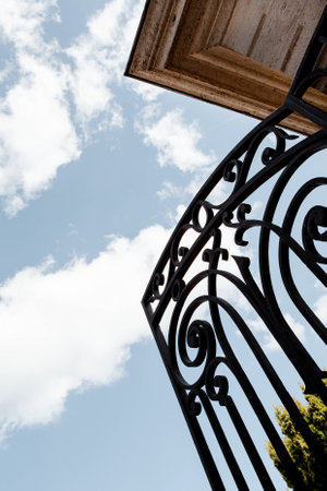 Open wrought iron gate and blue sky on backgroundの写真素材