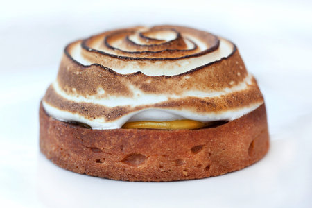 Close up of a lemon meringue pie on a white workplan