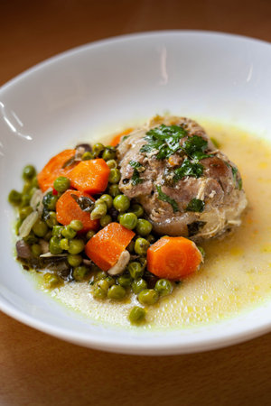 Veal roll with carrots and peas on a plateの写真素材