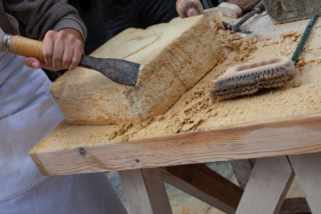 Stonemason working on a wooden tableの写真素材