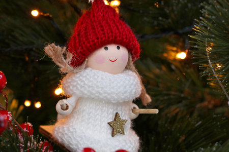 Christmas toy snowman on the background of a Christmas tree with red berries