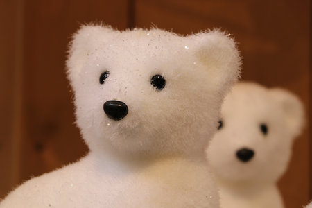 Cute white polar bear with glitters for indoor winter christmas decoration and one other in backgroundの写真素材