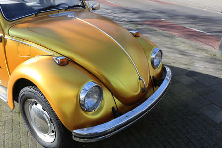 front of gold colored vintage Volkswagen beetle car on street in Bovenkarspel, the Netherlands, February 26 2022のeditorial素材