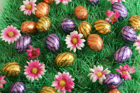 Easter eggs and flowers on green grass background. Happy Easter.の写真素材