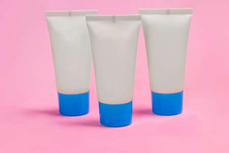 Trio of White Plastic Packaging Bottles on Pink and Blue Backgroundの写真素材