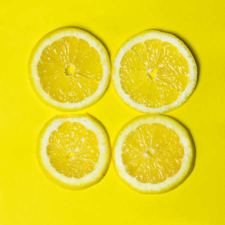 Four Lemon Slices on Yellow Backgroundの写真素材