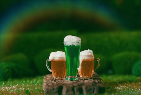 Saint Patrick's Day Beers Outdoors in Meadow Under a Rainbowの写真素材