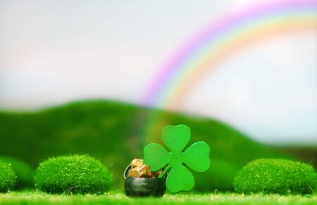 St. Patrick's Day Themed Pot of Gold with Four-Leaf Clover Under  Colorful Rainbow on a Clear Dayの写真素材
