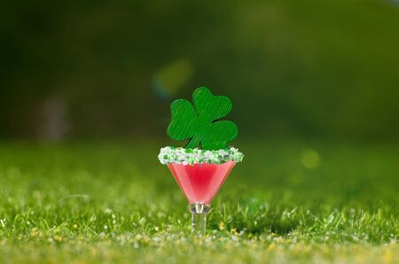 Single pink cocktail, a four-leaf clover on a grassy, green, outdoor meadowの写真素材