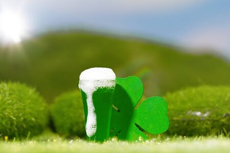 Outdoor Pint of Beer and Shamrock in Sunny Meadowの写真素材