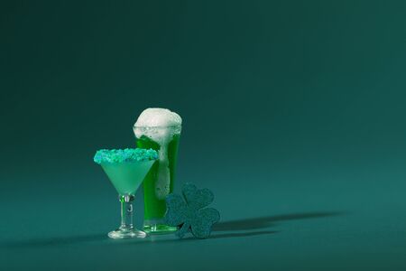 St. Patrick's Day Cocktail Beverage and Pint of Beer with Wood Clover on a Green Backgroundの写真素材