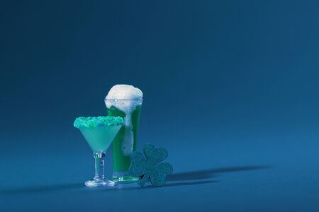 St. Patrick's Day Cocktail Beverage and Pint of Beer with Wood Clover on a Green Backgroundの写真素材
