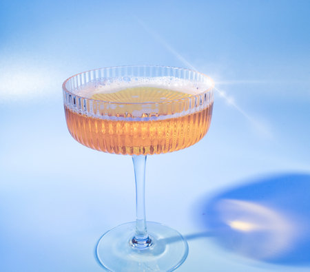 Gleaming Champagne Coupe with Bubbly Rose Beverage - High-Quality Image for Event Planners or Cocktail Recipe Blogsの写真素材